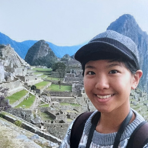 Julia with a cap infront of Machu Picchu